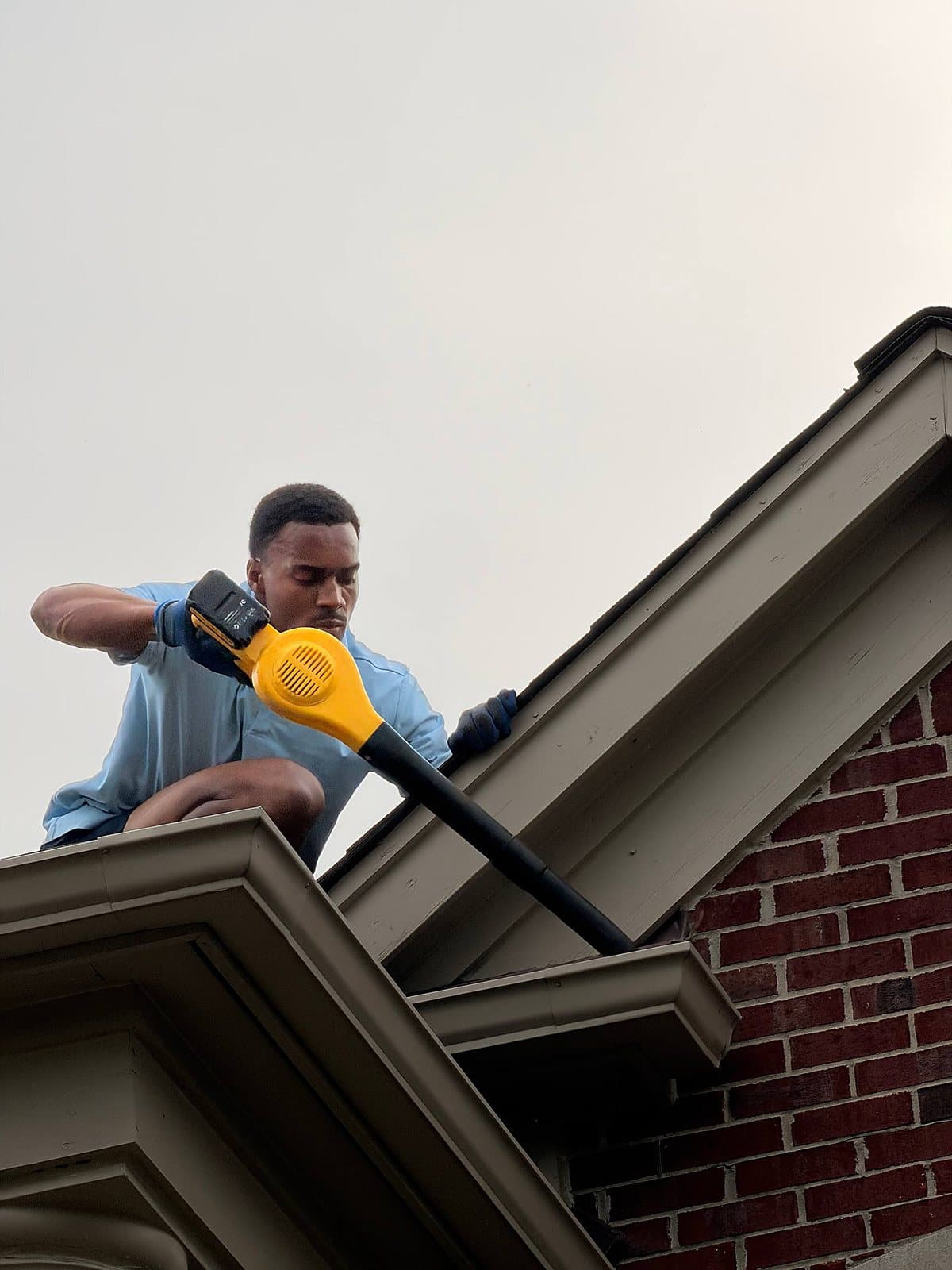 Clearing gutters from the roofline at a Metro Detroit home