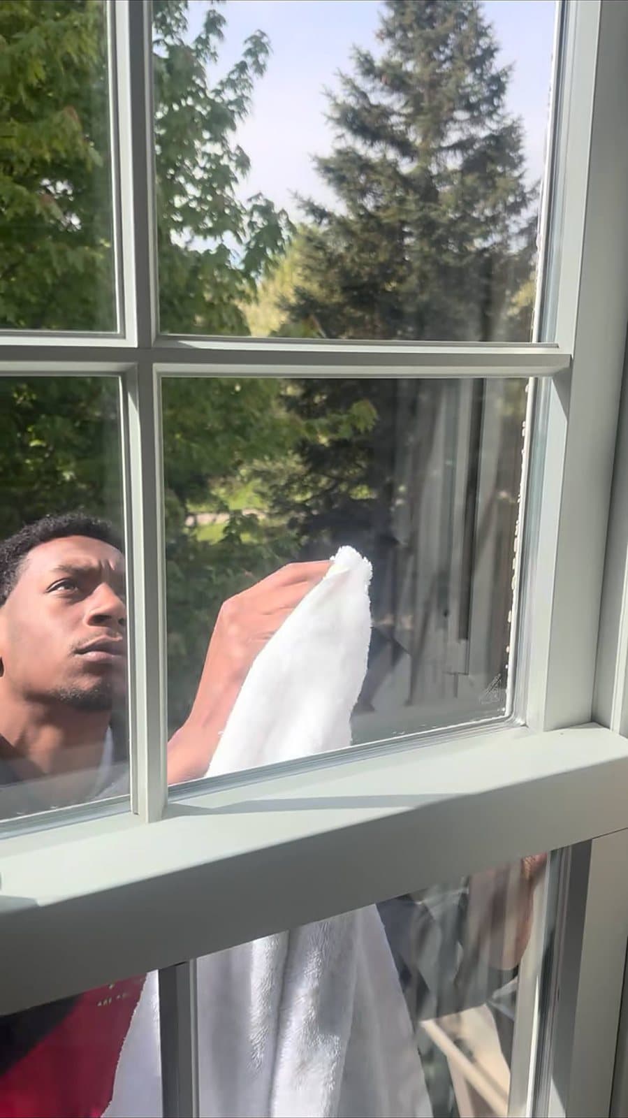 Wiping down glass during an interior window cleaning in Metro Detroit