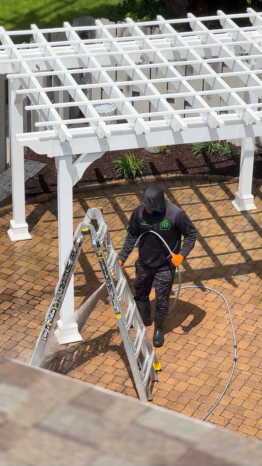 Are You Washed crew member washing a paver patio from a ladder in Metro Detroit
